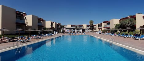 Piscina a l'aire lliure, para-sols i gandules