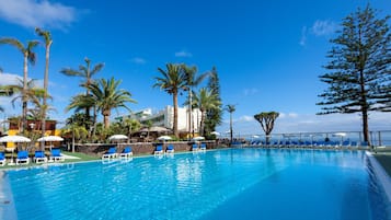 Piscine couverte, piscine extérieure, parasols de plage, chaises longues