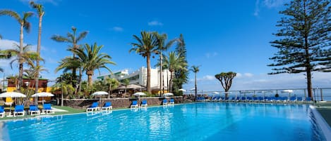 Piscine couverte, piscine extérieure, parasols de plage, chaises longues