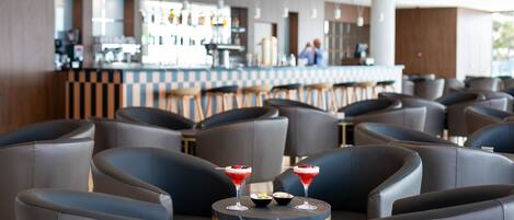 A modern bar area with leather seating and a bar counter.