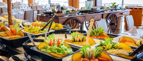 Un bufé con diversos alimentos y utensilios de servicio.