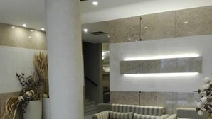 A modern lobby with a large column, a sofa set, and a coffee table. - Hotel Do Centro (Funchal)