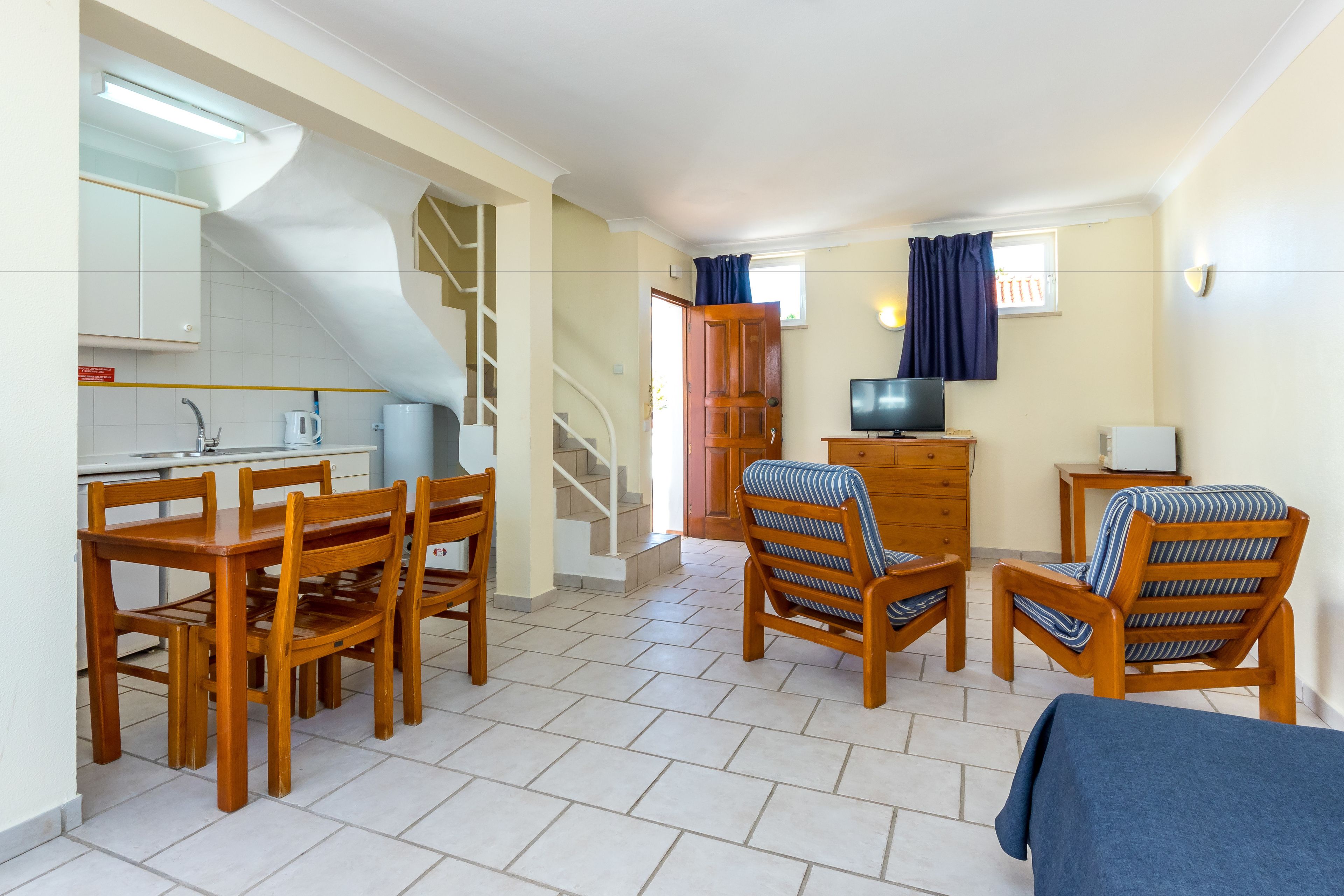 A compact living space with a kitchen, dining area, and a television.