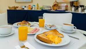 A breakfast table with toast, scrambled eggs, ham, and orange juice. - Apartamentos Turísticos Club Ouratlântico (Albufeira)