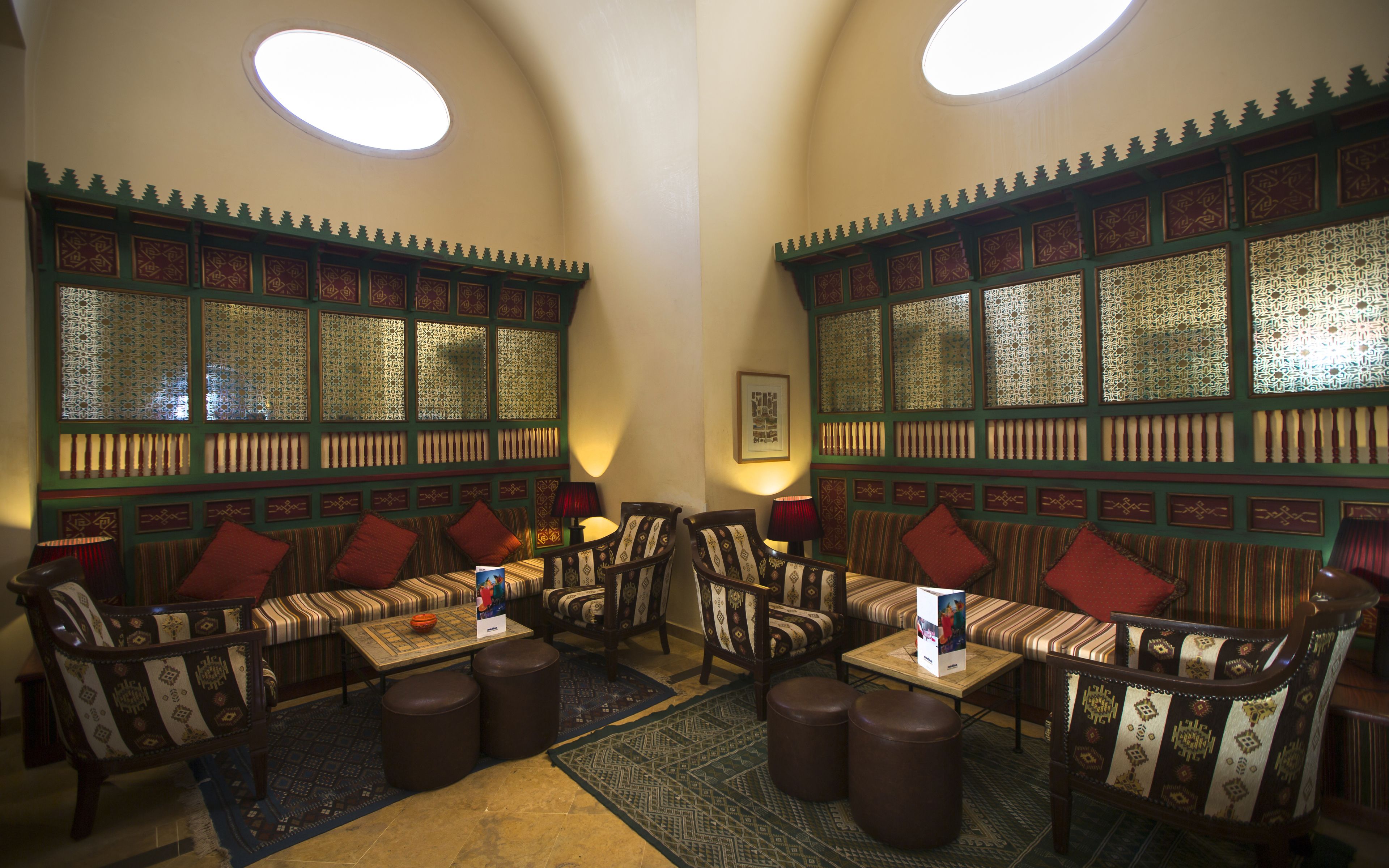 Una habitación con decoración tradicional, que presenta muebles con diseños estampados y elaborados motivos en las paredes.