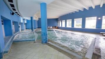 An indoor swimming pool with blue walls and a tiled floor.