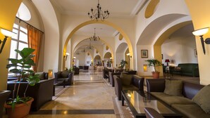 A hotel lobby with arched ceilings, a central chandelier, seating areas, and potted plants. - Medina Solaria & Thalasso (Hammamet)