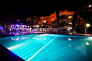 Una piscina al aire libre de temporada, sillones reclinables de piscina