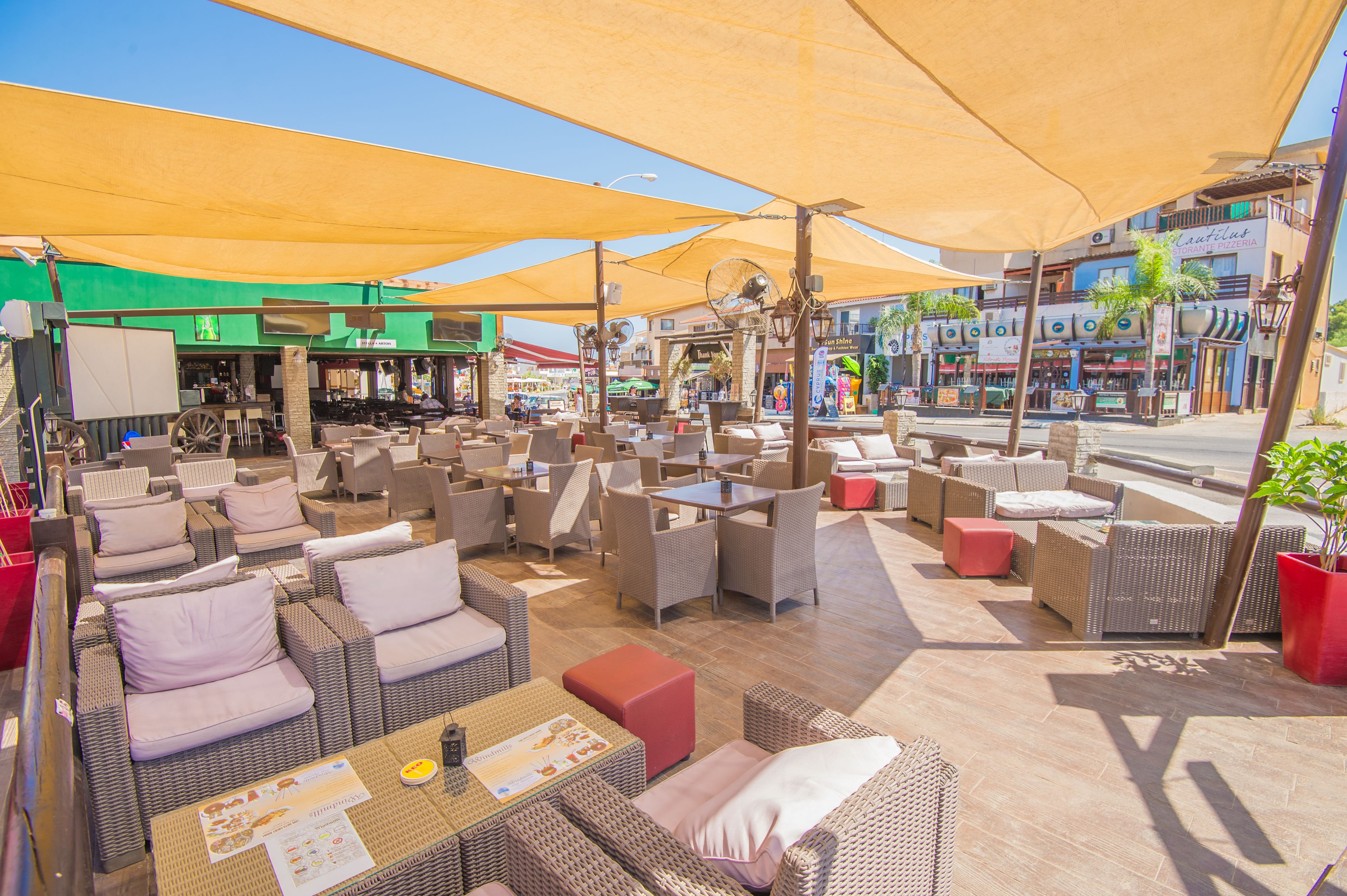 Un espace extérieur aménagé avec des meubles en osier et des parasols.