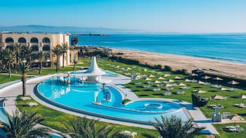 Una piscina al aire libre, sombrillas, tumbonas