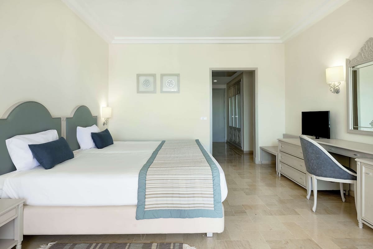 Een hotelkamer met een groot bed, een bureau, een stoel en een televisie.
