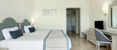 Habitación de hotel con una cama grande, un escritorio, una silla y un televisor.