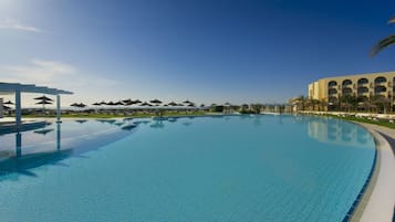 Una piscina al aire libre, sombrillas, tumbonas