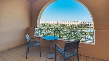 A balcony with a view of a building and palm trees.