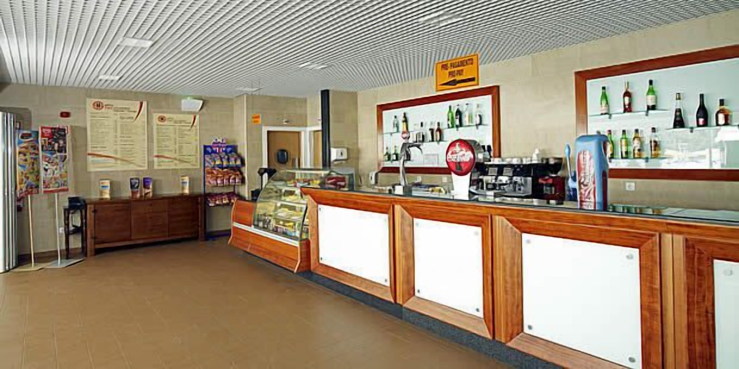 Un mostrador con una vitrina, una máquina de Coca-Cola y una exhibición de bebidas.