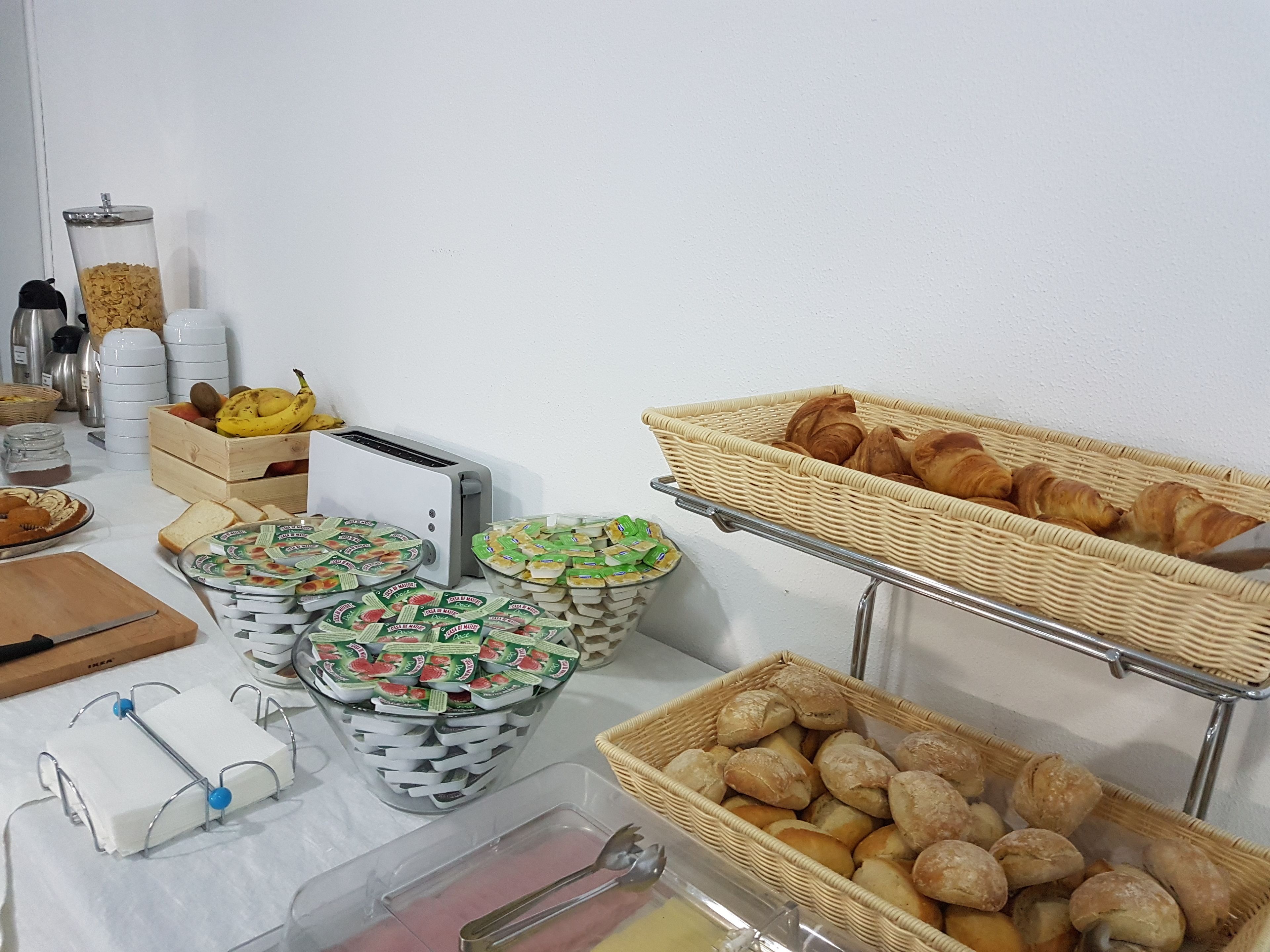 A breakfast buffet with various food items and utensils.