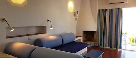 A modern living room with a blue sofa, a small table, and a fireplace.