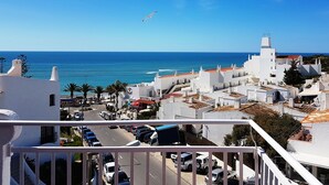 A coastal town with white buildings, a clear blue sky, and a seagull flying. - Apartamentos Soldoiro (Albufeira)