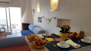 A breakfast setup with croissants, orange juice, and a pitcher of juice on a marble table. - Apartamentos Soldoiro (Albufeira)