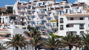 A coastal building with multiple balconies, a sign reading "SOLDOIRO," and palm trees in the foreground. - Apartamentos Soldoiro (Albufeira)