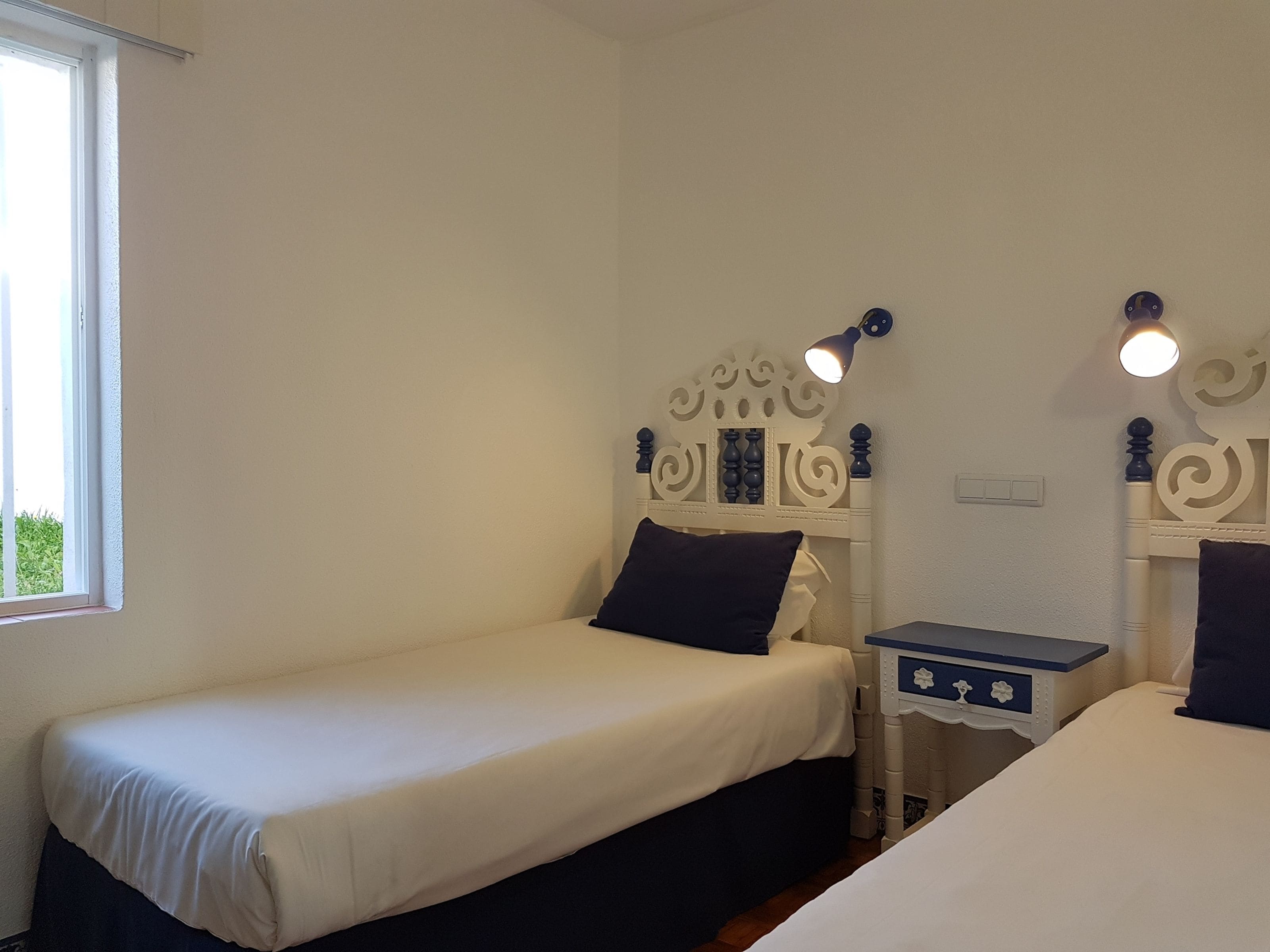 A twin room with two single beds, each with a nightstand and a lamp.