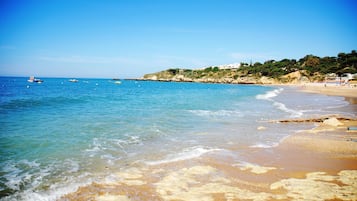 Una playa cerca, sombrillas, toallas de playa