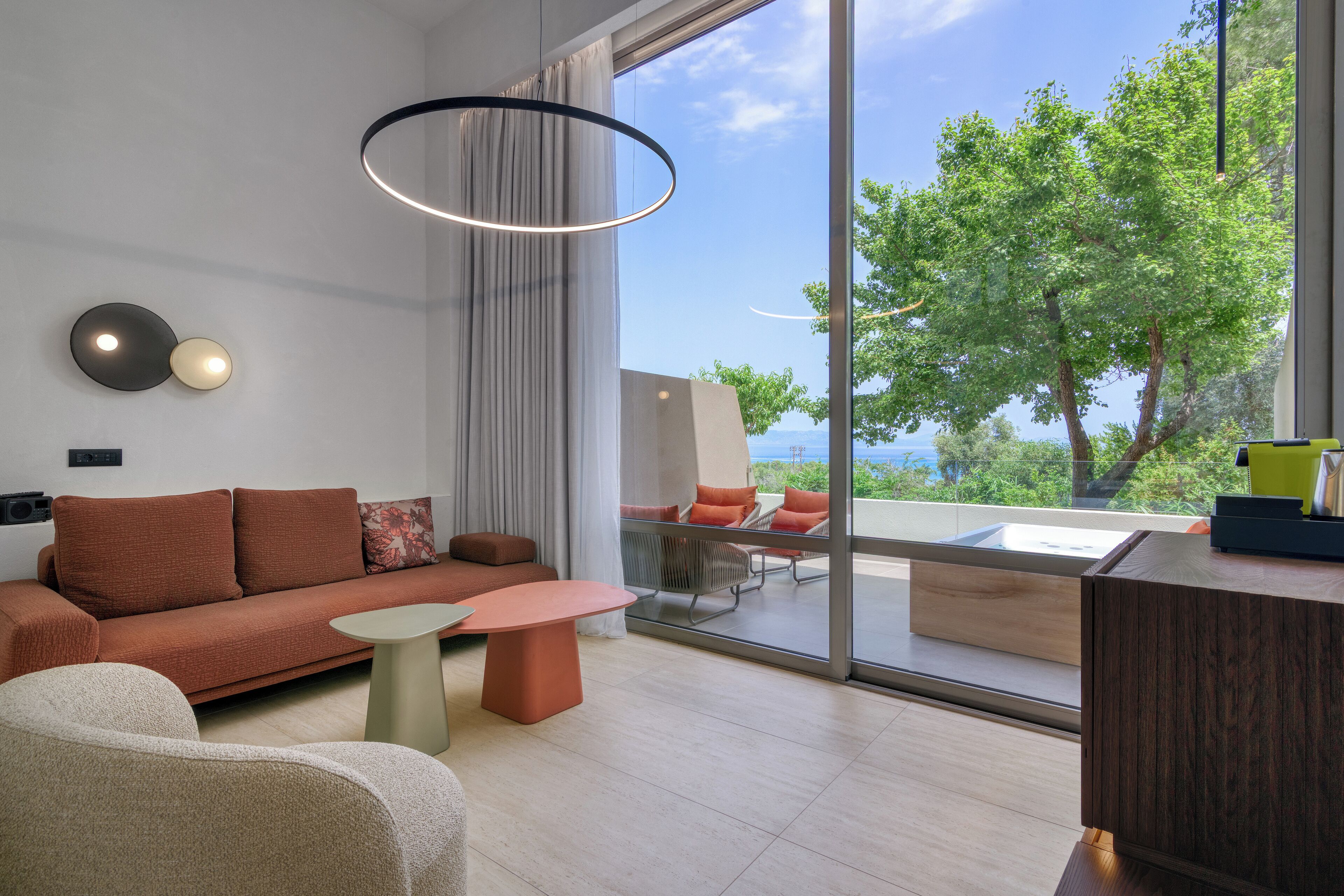 Una sala de estar moderna con un sofá, una mesa de centro y vistas al exterior.