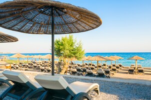 Nyilvános parton, napozóágyak, napernyők és strandlepedők