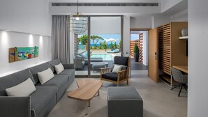 Un salon moderne avec un canapé gris, une table basse en bois et un pouf gris. On y trouve également un meuble en bois sur lequel est posé un vase. Un tableau orne le mur, et une fenêtre offre une vue sur une piscine et un espace verdoyant.