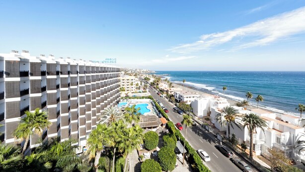 A hotel with a pool, beach view, and palm trees. - Relaxia Beverly Park (San Bartolomé de Tirajana)