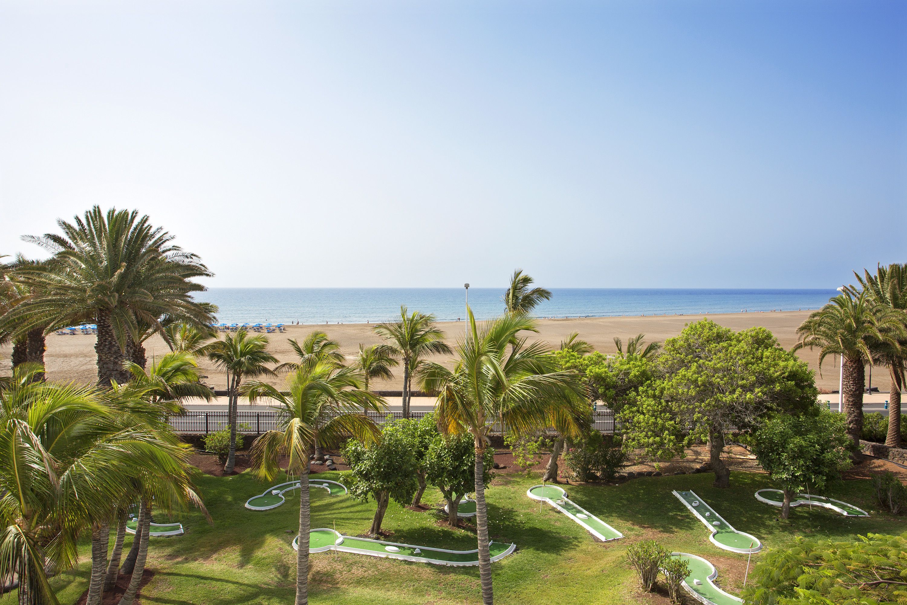 Un campo de golf con vista a la playa y el océano.