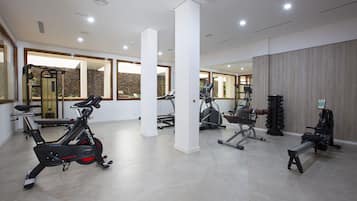 A modern gym with stationary bikes, treadmills, and weight machines.