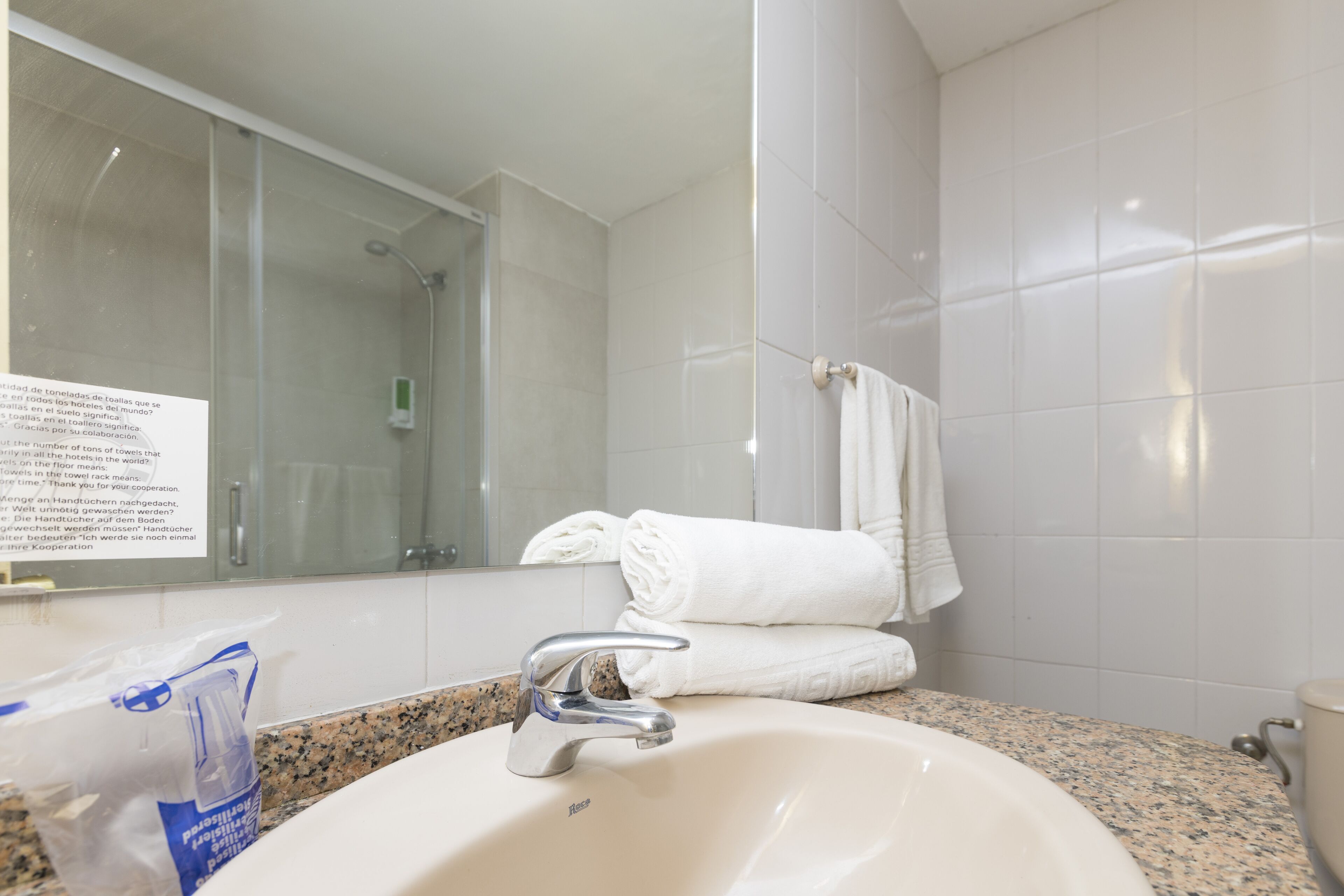 A bathroom with a sink, mirror, and towel rack.