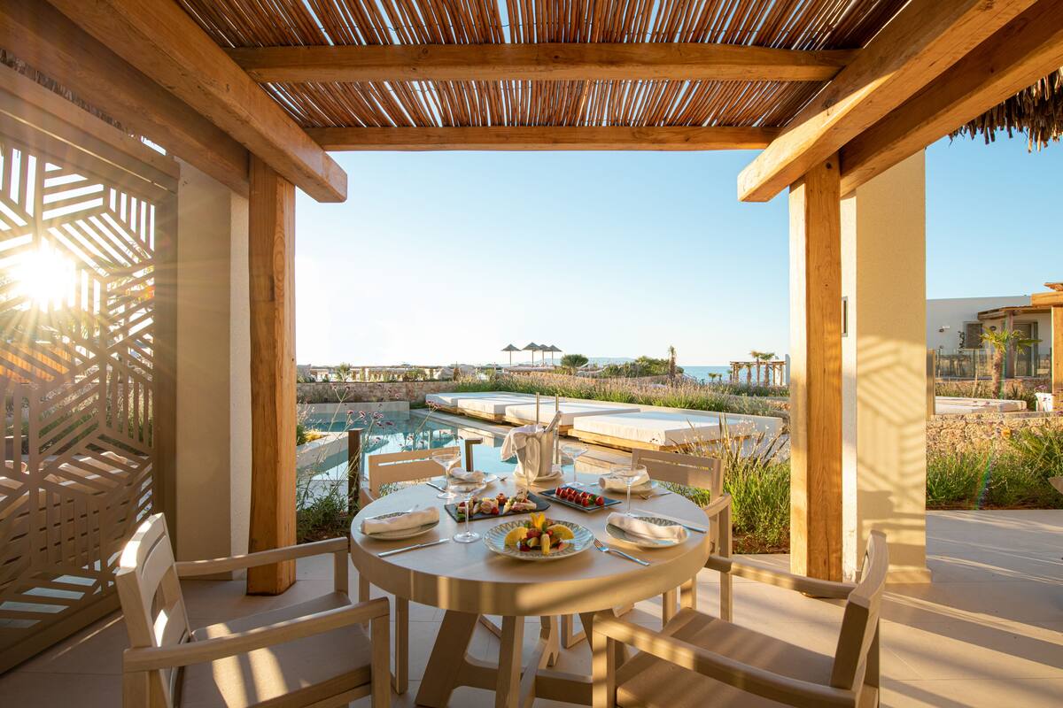 Un espace de restauration en plein air avec vue sur une piscine et l’océan.