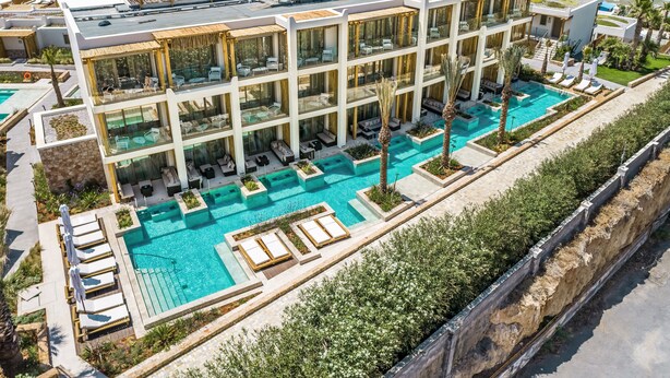 A modern hotel with a rooftop pool, multiple balconies, and a view of the sea. - Mitsis Selection Rinela (Hersonissos)