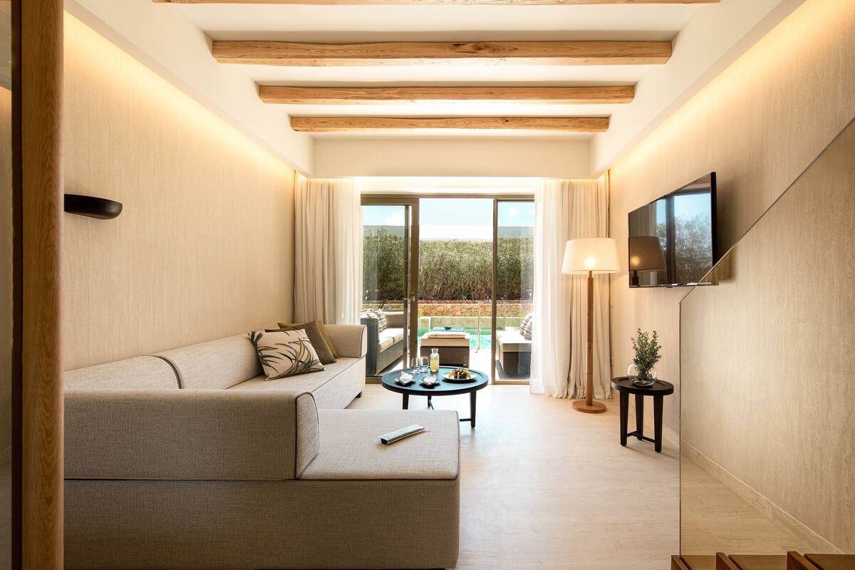 Un salon moderne avec un canapé, une table basse et un téléviseur fixé au mur.