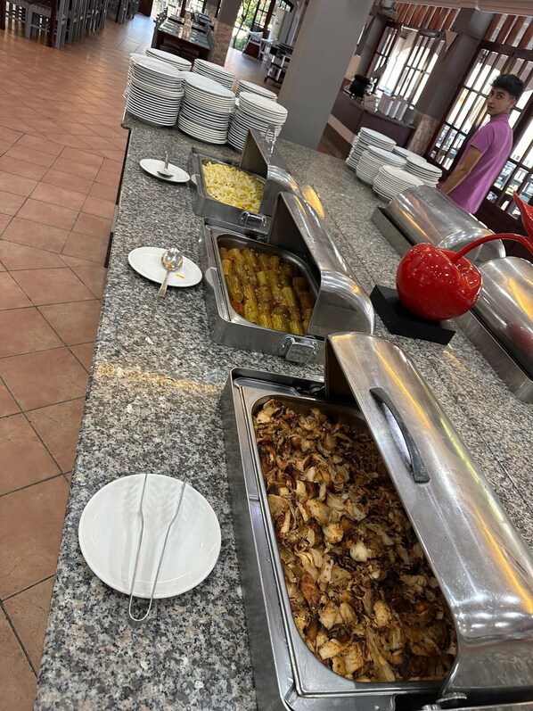 Una mesa de buffet con distintos alimentos y utensilios.