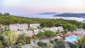 A hotel with multiple buildings, a swimming pool, and a view of the sea. - Pigale Beach Resort (Kusadasi)
