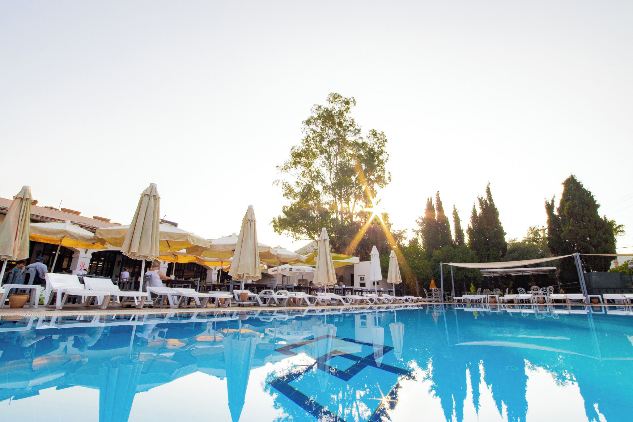 A swimming pool with sun umbrellas and lounge chairs.