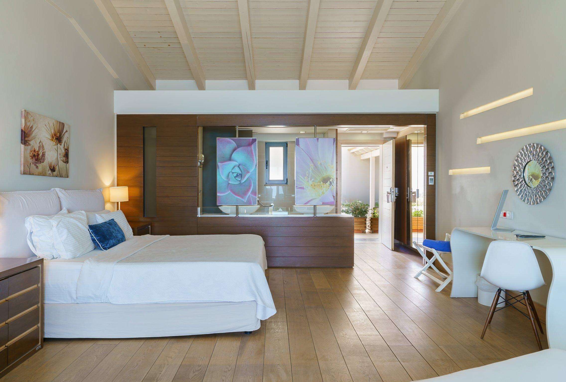 Habitación de hotel moderna con una cama grande, un escritorio y vistas al exterior.