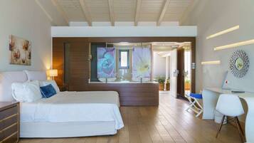 Habitación de hotel moderna con una cama grande, un escritorio y vistas al exterior.