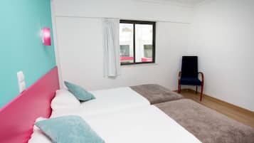 Un dormitorio con cama, una silla, una ventana y vistas a un balcón.