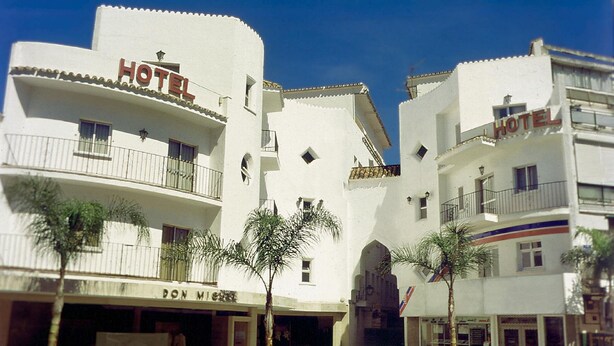 A hotel with multiple balconies and a central courtyard with palm trees. - Hotel Kristal (Torremolinos)