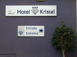 Une enseigne indiquant l’hôtel Kristal, avec une flèche pointant vers l’entrée.