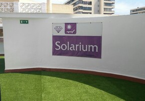 Een muur met een spandoek waarop “Solarium” staat en een bord dat een uitgang aangeeft.