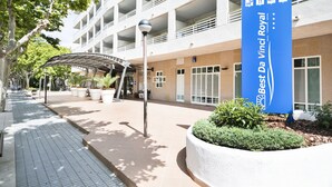 A hotel entrance with a large blue sign, a covered walkway, and a landscaped area. - Hotel Best Da Vinci  (Salou)