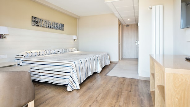 A modern hotel room with a large bed, a desk, a flat-screen TV, and a painting on the wall. - Hotel Best Da Vinci  (Salou)