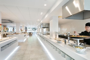 A modern buffet setup with multiple serving stations, a chef preparing food, and a clean, well-lit interior. - Hotel Best Da Vinci  (Salou)