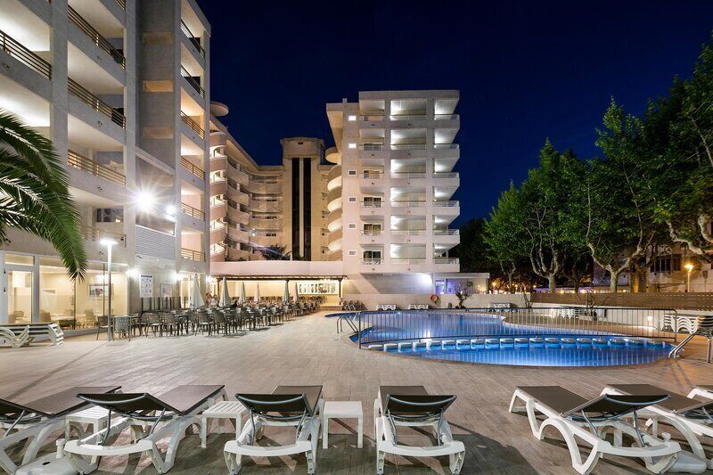 Una piscina al aire libre, sombrillas, tumbonas