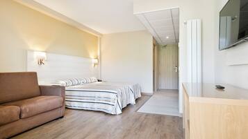 Ein modernes Hotelzimmer mit einem großen Bett, einer Couch und einem Holztisch.